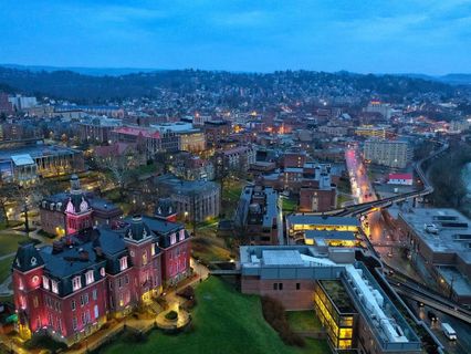 WVU downtown campus at dusk with night time lights illuminating the city